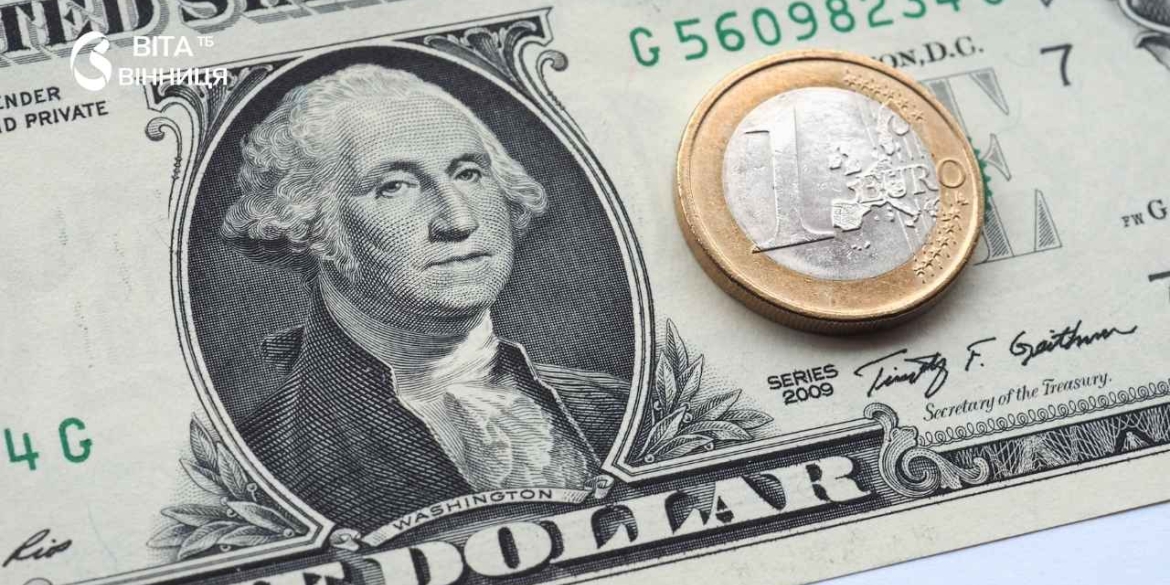Банкноти доларів США та євро поруч із гривнями на столі — офіційний курс валют для вінничан