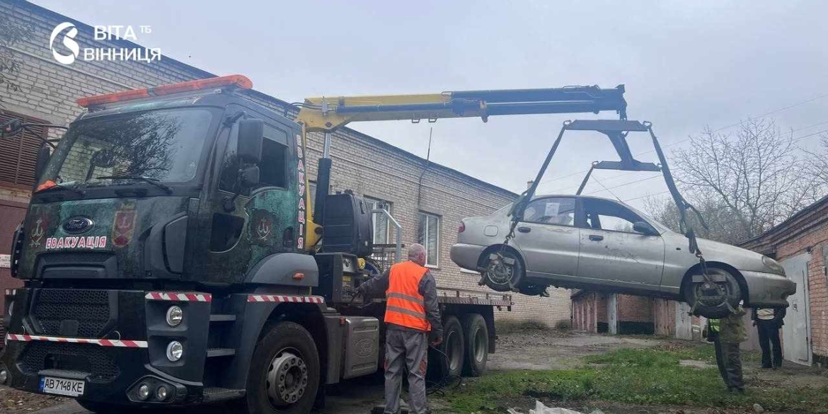 Покинутий автомобіль із проржавілим кузовом і колесами, що вросли в землю, прибирають з дворів багатоповерхівок у Вінниці