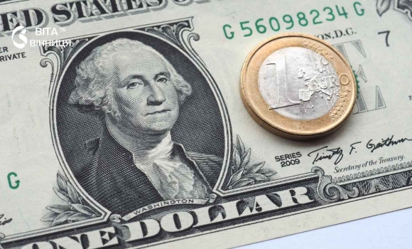 Банкноти доларів США та євро поруч із гривнями на столі — офіційний курс валют для вінничан