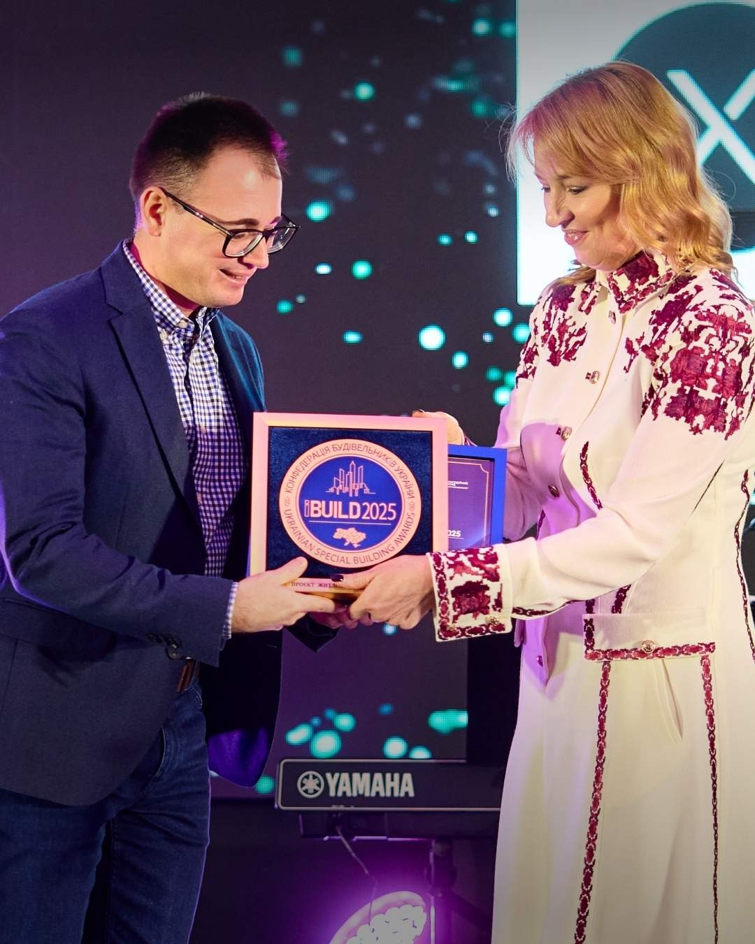 Житловий комплекс The TENTH House переможець престижної премії iBuild 2025. Це перший ЖК у Вінниці, який відзначено подібною нагородою за архітектурну складність та довершеність. Нагородження відбулося в Києві. Відзначення кращих серед кращих в будівельній сфері об’єднало понад 250 гостей — лідерів будівельної галузі, представників органів державної влади та міжнародних компаній. The TENTH House від девелопера D121 — це перший житловий комплекс бізнес-класу у Вінниці, який поєднує унікальну архітектуру у формі “X”, скандинавську естетику та концепцію work-life balance. Комплекс складається з двох 9-поверхових будинків та двох 24-поверхових веж, що створюють новий архітектурний символ міста. Комплекс будується в районі Вишенька і буде об’єднаний спільним простором із одним з найбільших торговельних центрів Вінниці Plaza Park. В пішій доступності ринок, лікарні, зупинки громадського транспорту, озеро та парк. iBuild — це найпрестижніша будівельна премія України, яку щороку вручає Конфедерація будівельників України. Нагорода відзначає компанії, які попри всі виклики продовжують розвивати галузь та створювати якісне житло для українців. Нагороди в інших категоріях також отримали Інтеграл-буд, Kan Development, ПБФ Девелопмент та інші.