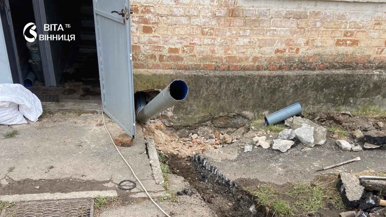 <p><strong>У Калинівці на будинку №19 по вулиці Шевченка комунальники знайшли нестандартне рішення для заміни застарілої каналізації, яка десятиліттями не знала капітального ремонту.</strong></p> <p>Про це 10 липня повідомляє <a href="https://vitatv.com.ua/">ВІТА ТБ</a> посилаючись на <a href="https://kalynivka-mr.gov.ua/" rel="nofollow">Калинівську міську раду</a>.</p> <blockquote><p>Будинок зведений ще у 1962 році за специфічним архітектурним проєктом тих часів — без підвальних приміщень, тому всі інженерні комунікації прокладені безпосередньо під підлогою квартир першого поверху, — йдеться у повідомленні.</p></blockquote> <p>Через таку конструкцію мережі безперебійно працювали понад шістдесят років без жодної заміни, адже будь-яке втручання вимагало б повного демонтажу підлоги в оселях мешканців.</p> <p>Аварійна бригада два дні поспіль намагалася пробити застаріле засмічення. Слідом за традиційним металевим дротом комунальники застосували спеціальну гідродинамічну машинку з пружинами, проте зношена чавунна труба не піддалася чищенню.</p> <p>Тоді постало питання про повну заміну аварійного стояка на сучасний пластиковий. Головною проблемою стало те, що труба проходить під підлогою кухні літньої жительки будинку — щоб уникнути руйнування приватного житла та зберегти ремонт у квартирі пенсіонерки, фахівці розробили альтернативний план.</p> <h2>Компромісне рішення комунальників</h2> <p>Директор комунального підприємства «Управляюча компанія «Житловик»» Віталій Шатов зазначив, що ремонт у будинках такої конструкції завжди є іспитом на винахідливість для майстрів, а руйнувати підлогу та кухню літньої жінки підприємство не мало морального права. За його словами, оцінивши всі технічні ризики, комунальники разом із мешканцями під'їзду ухвалили компромісне рішення: нову пластикову мережу водовідведення прокладуть в обхід квартири — безпосередньо через під'їзд.</p> <p>Це дозволить повністю зняти проблему аварійності, зберегти спокій та майно людей, а також забезпечити швидкий доступ до труби для її обслуговування в майбу