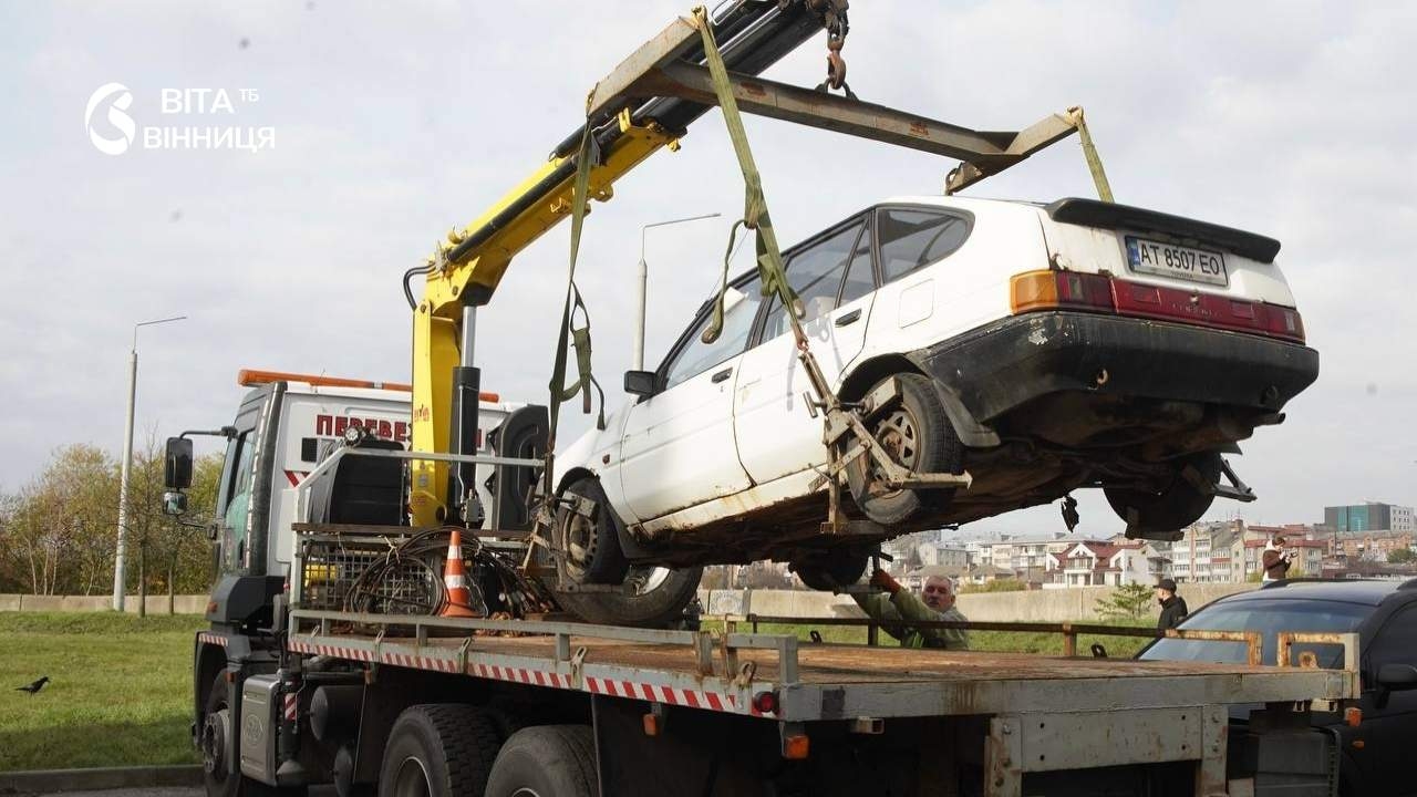 Покинутий автомобіль із проржавілим кузовом і колесами, що вросли в землю, прибирають з дворів багатоповерхівок у Вінниці