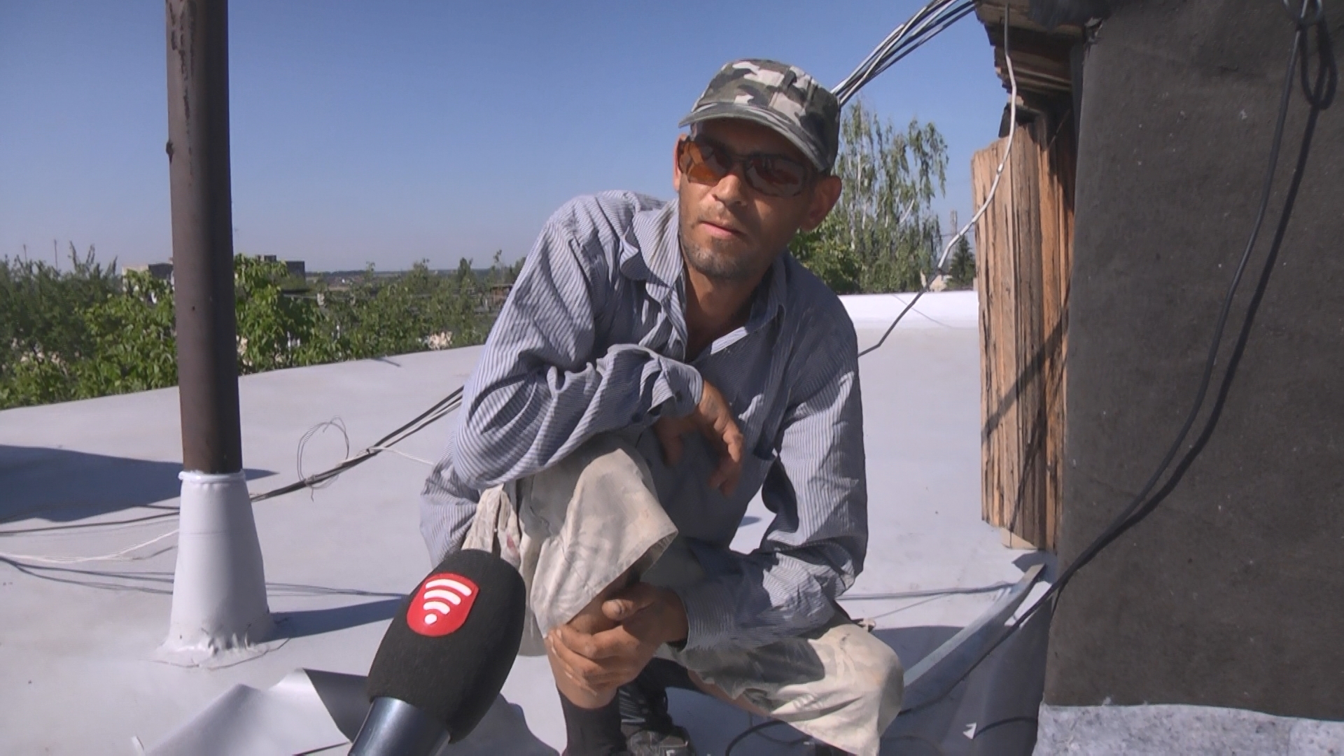 будівельник стелить руберойд на дахах багатоповерхівок у Вінниці